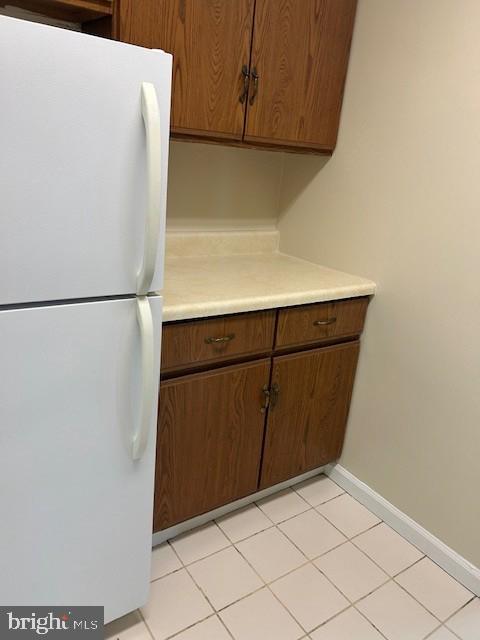 kitchen featuring light countertops, freestanding refrigerator, and baseboards