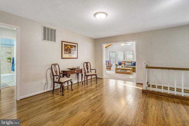 living area with visible vents, baseboards, and wood finished floors