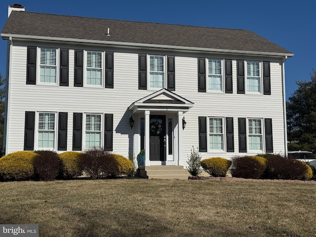 colonial-style house with a front lawn