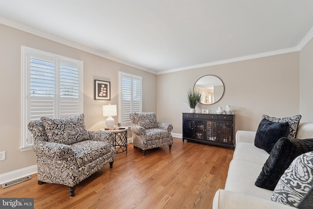 living room featuring baseboards, wood finished floors, visible vents, and crown molding