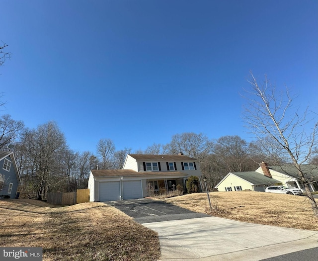 view of front of home with driveway, a garage, and fence