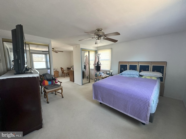 bedroom featuring a ceiling fan and light colored carpet