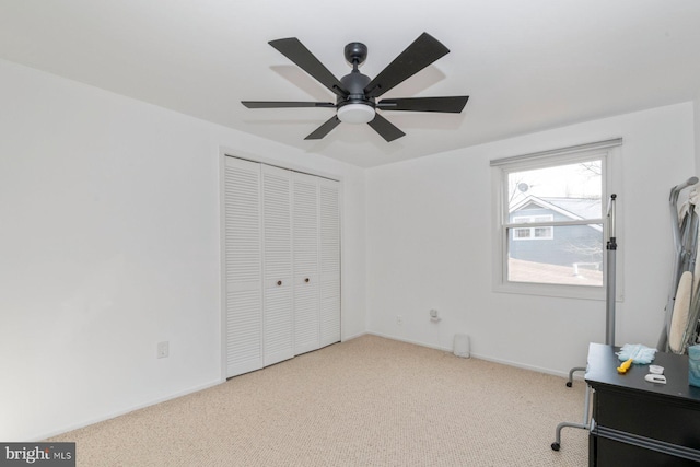 carpeted bedroom featuring a closet, ceiling fan, and baseboards