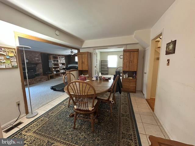 dining space with a ceiling fan, light colored carpet, visible vents, and light tile patterned floors