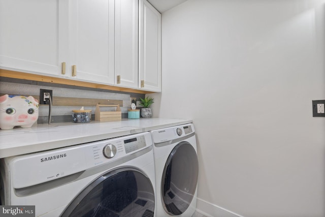 laundry area featuring cabinet space, baseboards, and washer and clothes dryer