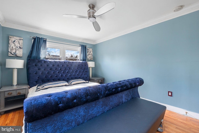 bedroom featuring crown molding, baseboards, and wood finished floors