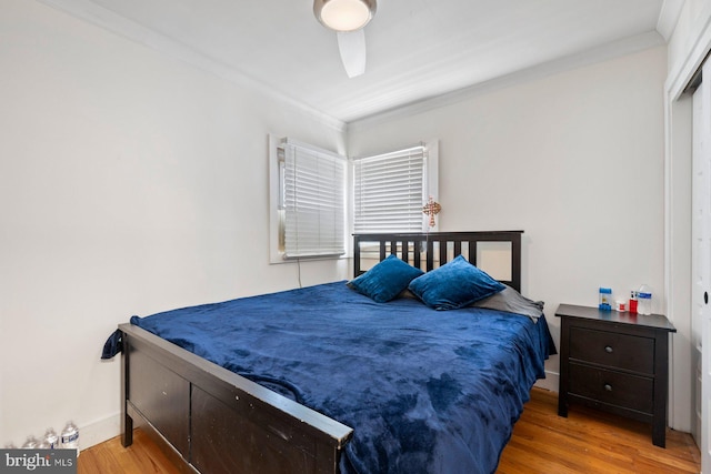 bedroom featuring ornamental molding, baseboards, and wood finished floors