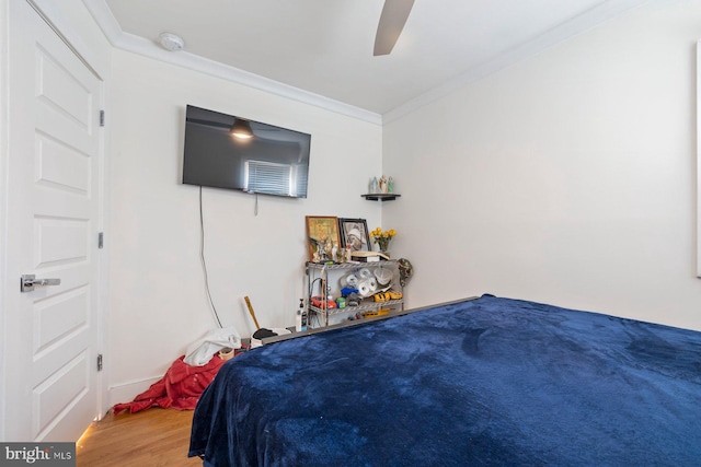 bedroom featuring ceiling fan, crown molding, and wood finished floors