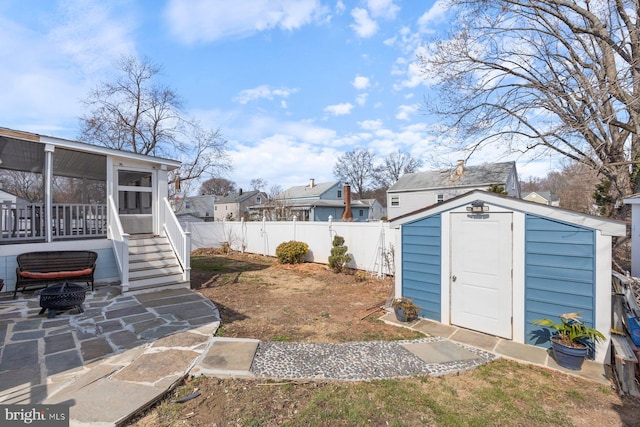 view of yard with a storage unit, a sunroom, a patio area, a fenced backyard, and an outdoor structure