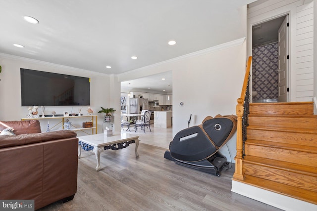 living area with crown molding, stairway, and wood finished floors