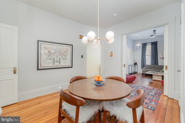 dining room featuring hardwood / wood-style flooring, baseboards, and a chandelier