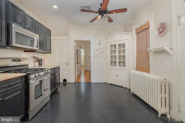 kitchen featuring visible vents, appliances with stainless steel finishes, tasteful backsplash, radiator heating unit, and crown molding