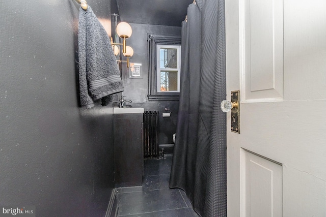 bathroom with tile patterned flooring, vanity, and radiator