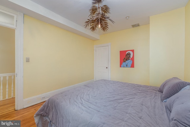 bedroom with light wood finished floors, baseboards, and visible vents