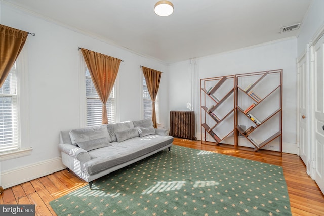 living room featuring ornamental molding, radiator, plenty of natural light, and hardwood / wood-style flooring