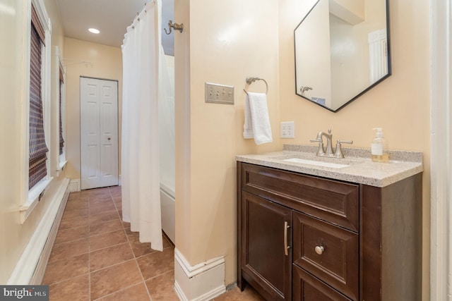 full bath featuring tile patterned floors, baseboards, curtained shower, and vanity