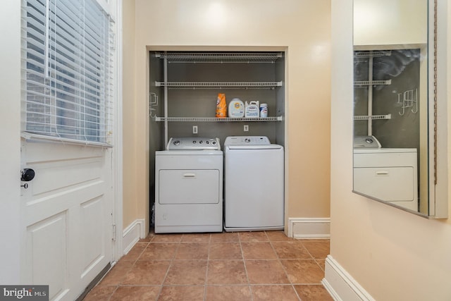 laundry area featuring laundry area, washer and clothes dryer, tile patterned flooring, and baseboards