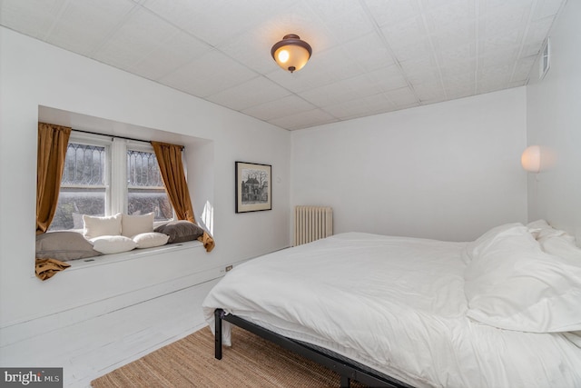 bedroom with visible vents and radiator heating unit