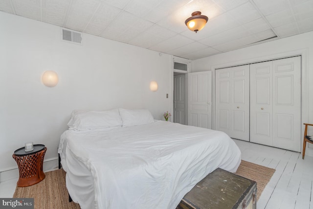 bedroom with a closet, visible vents, and light wood-style flooring