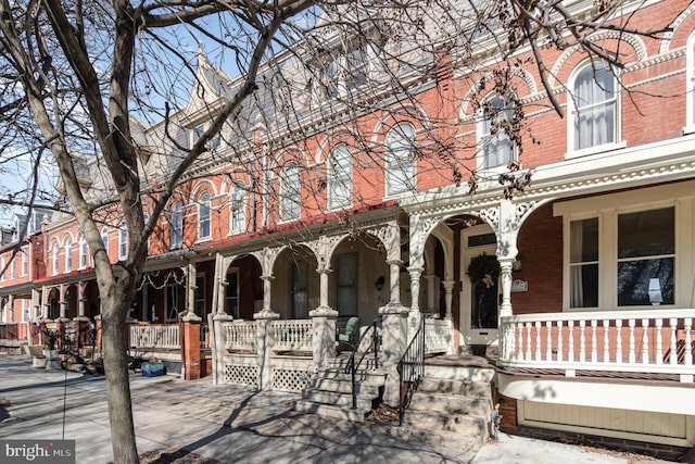 view of front of property featuring covered porch and brick siding