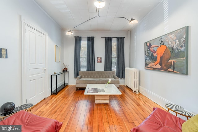 living area featuring light wood-type flooring, radiator heating unit, and baseboards