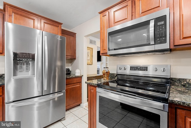 kitchen with light tile patterned flooring, visible vents, brown cabinets, and stainless steel appliances