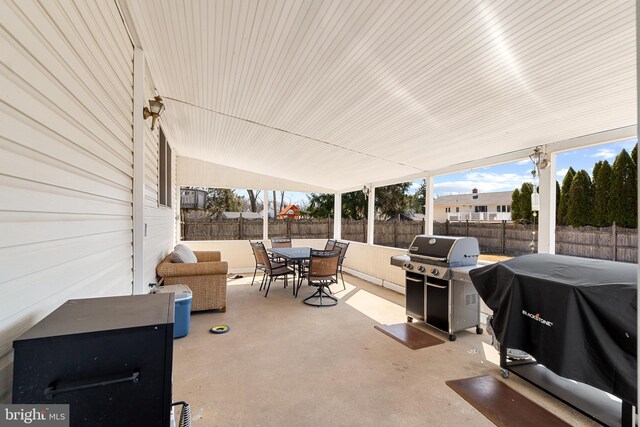 view of patio with area for grilling, outdoor dining area, and a fenced backyard