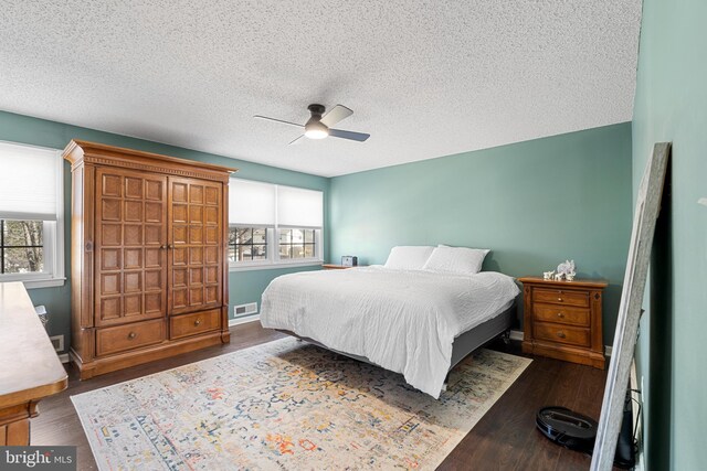 bedroom with dark wood-type flooring, multiple windows, and visible vents