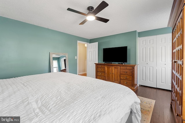 bedroom featuring a closet, a textured ceiling, dark wood finished floors, and a ceiling fan