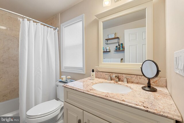 full bathroom with toilet, vanity, and shower / bath combo