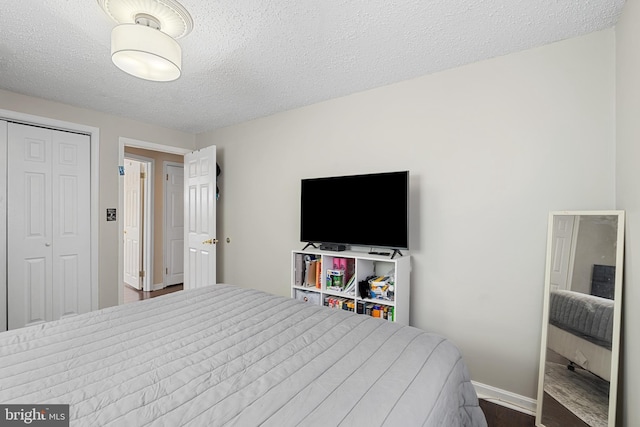 bedroom with a closet, baseboards, and a textured ceiling