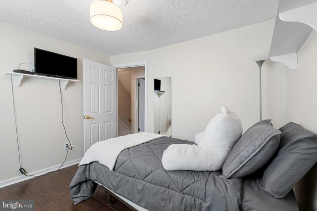 bedroom featuring a textured ceiling and wood finished floors