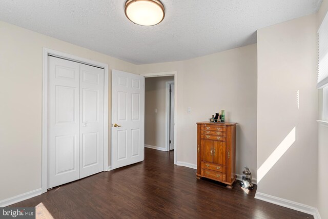 bedroom featuring wood finished floors, baseboards, a closet, and a textured ceiling