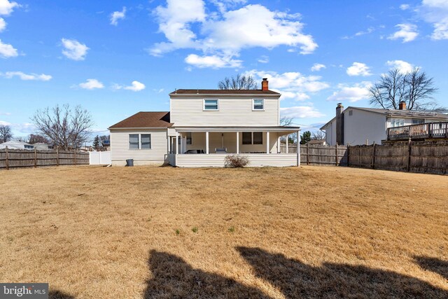 rear view of property with a porch, a lawn, and a fenced backyard