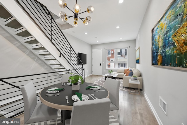 dining room featuring baseboards, stairway, wood finished floors, a notable chandelier, and recessed lighting