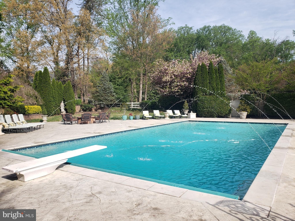 outdoor pool with a patio area