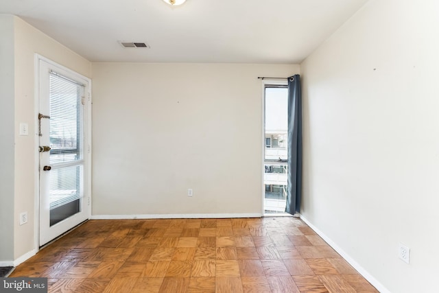 empty room with visible vents and baseboards