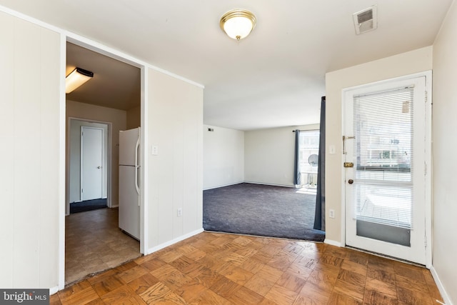 foyer with baseboards and visible vents