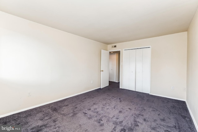 unfurnished bedroom featuring a closet, carpet, visible vents, and baseboards