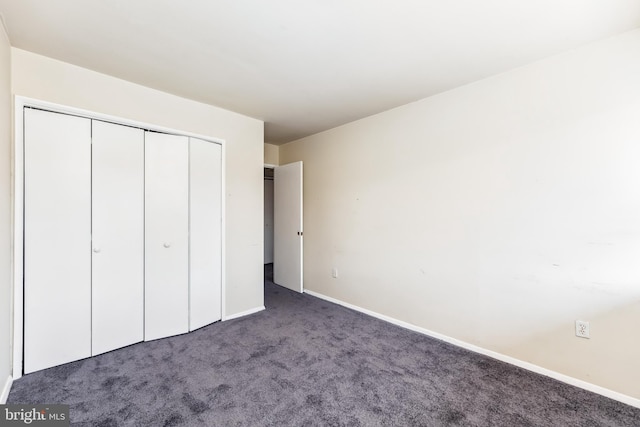 unfurnished bedroom featuring a closet, carpet, and baseboards