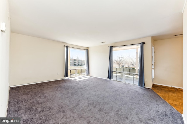 empty room featuring carpet floors and baseboards