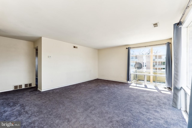 carpeted empty room featuring visible vents