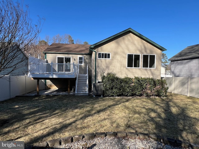 rear view of house with a deck, stairway, a yard, and a fenced backyard