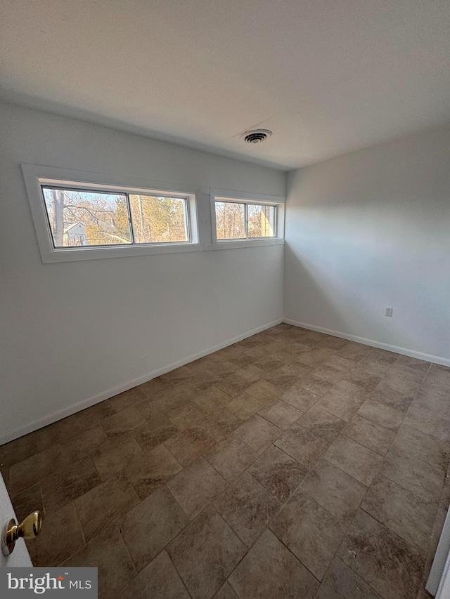 spare room featuring baseboards and visible vents