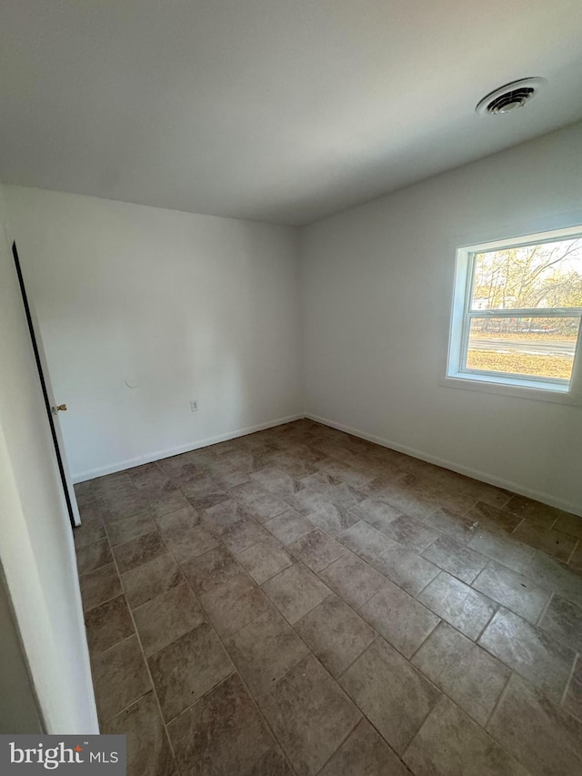 empty room with baseboards and visible vents