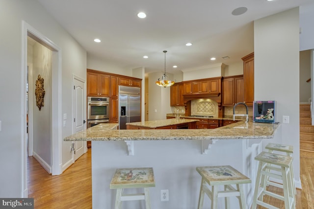 kitchen featuring a sink, decorative backsplash, a kitchen breakfast bar, and stainless steel appliances