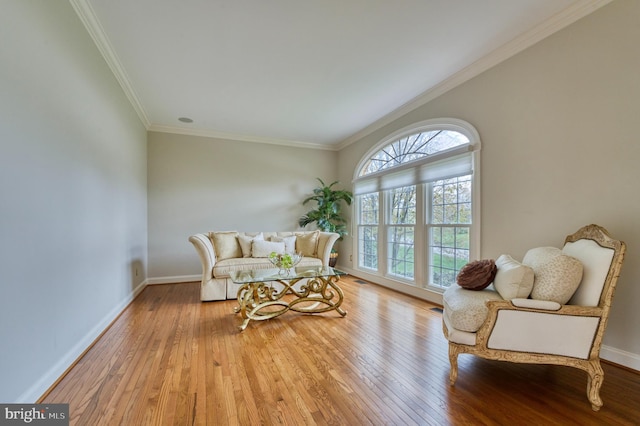 living area with hardwood / wood-style floors, baseboards, and ornamental molding