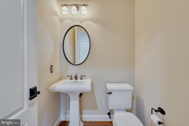 half bath with toilet and baseboards