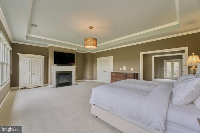 carpeted bedroom featuring visible vents, a tray ceiling, baseboards, and a premium fireplace