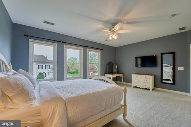 carpeted bedroom featuring visible vents, baseboards, and ceiling fan